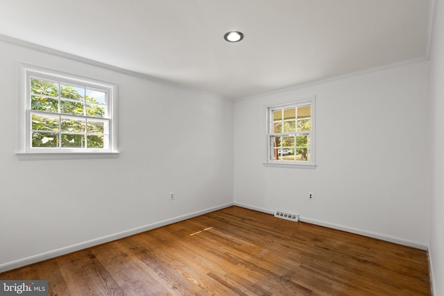 unfurnished room featuring crown molding, hardwood / wood-style flooring, and plenty of natural light