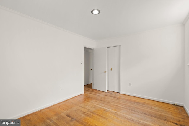 spare room with ornamental molding and light wood-type flooring