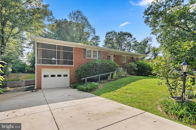 view of front facade with a front lawn, a garage, and a sunroom