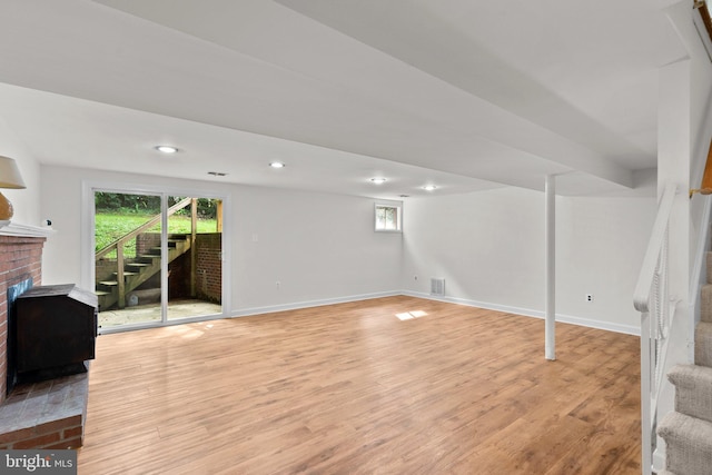 basement featuring light hardwood / wood-style flooring and a fireplace