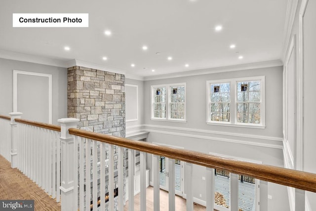 corridor with light hardwood / wood-style floors and ornamental molding