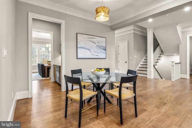 dining area featuring crown molding, light hardwood / wood-style floors, and an inviting chandelier