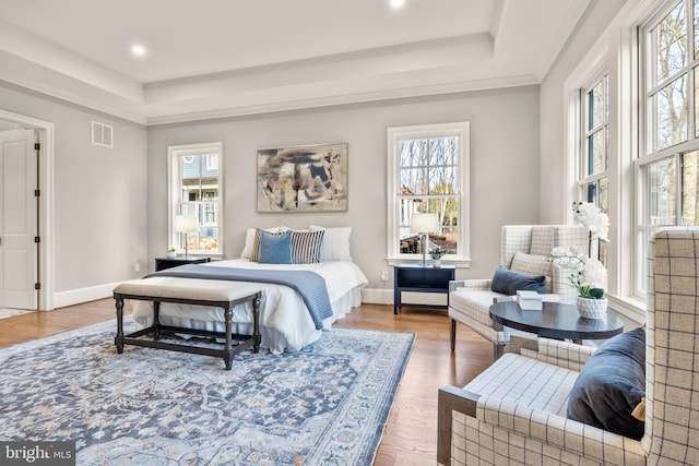 bedroom featuring multiple windows, ornamental molding, and hardwood / wood-style flooring