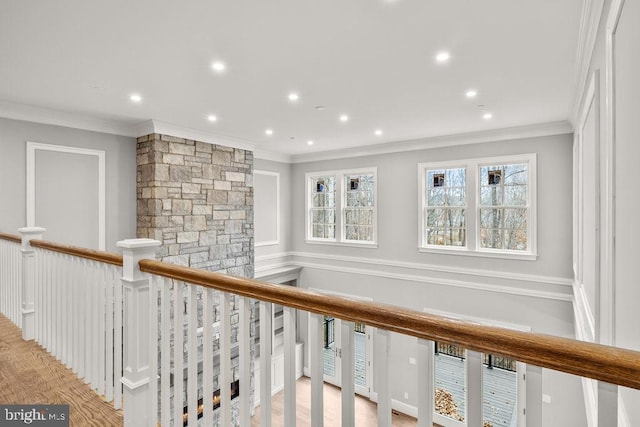 corridor with light hardwood / wood-style floors and ornamental molding