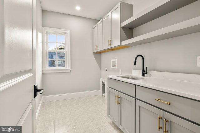 clothes washing area featuring hookup for a washing machine, sink, cabinets, and hookup for an electric dryer