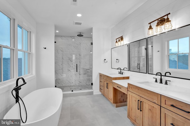 bathroom with vanity, shower with separate bathtub, and a water view