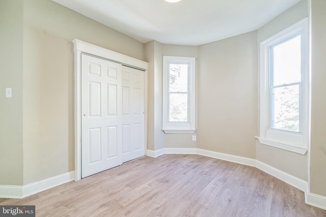 unfurnished bedroom with light hardwood / wood-style floors and a closet