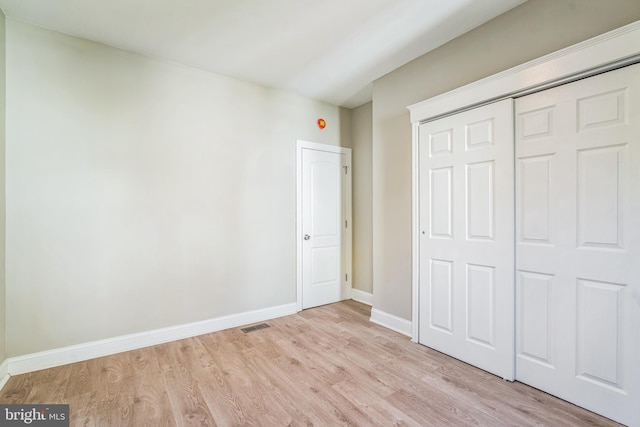 unfurnished bedroom featuring a closet and light wood-type flooring