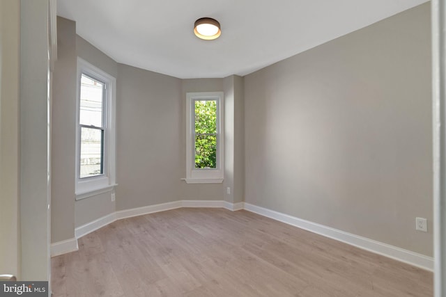 spare room with a wealth of natural light and light wood-type flooring