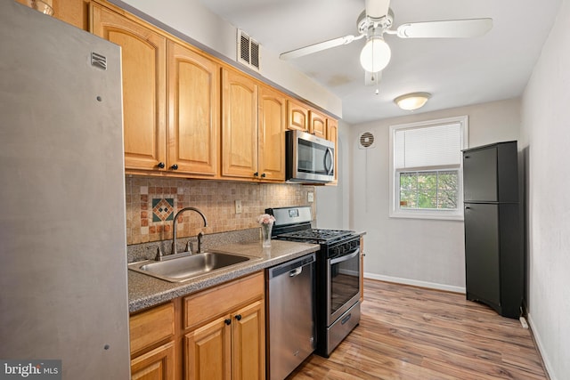 kitchen with tasteful backsplash, ceiling fan, sink, light hardwood / wood-style floors, and stainless steel appliances