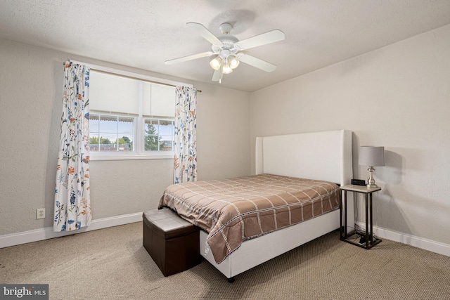 carpeted bedroom with a textured ceiling and ceiling fan