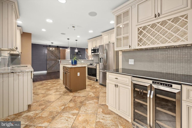 kitchen with cream cabinetry, decorative light fixtures, beverage cooler, and stainless steel appliances