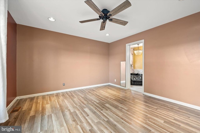 interior space featuring light hardwood / wood-style floors and ceiling fan with notable chandelier