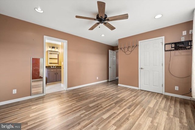 unfurnished bedroom with light hardwood / wood-style flooring, ensuite bathroom, sink, and ceiling fan