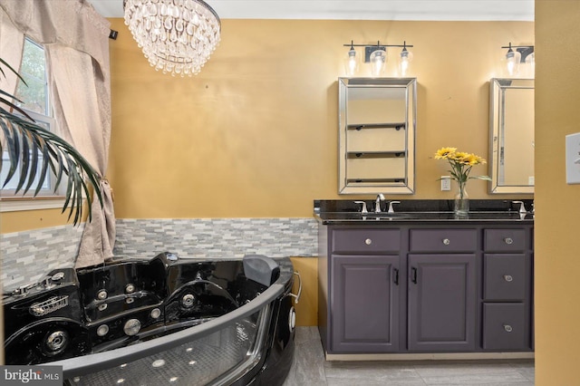 bathroom with vanity, a notable chandelier, a tub, and tasteful backsplash