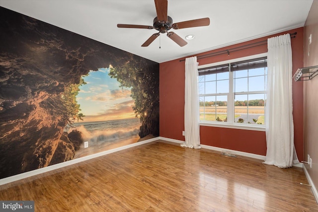 spare room featuring wood-type flooring and ceiling fan