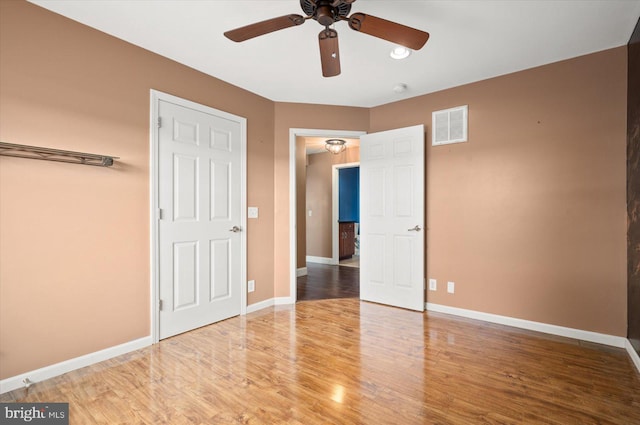 unfurnished bedroom with ceiling fan and hardwood / wood-style floors