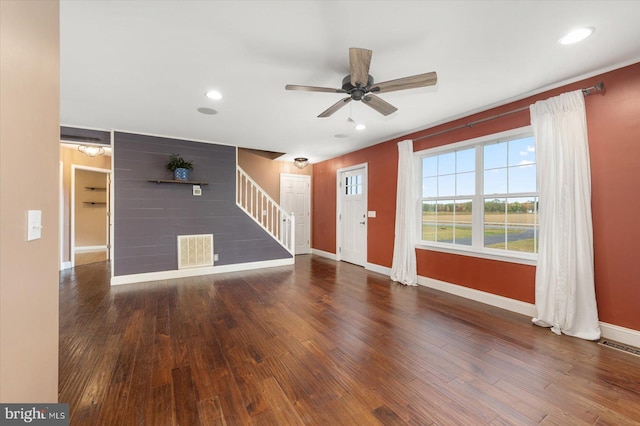 unfurnished living room featuring dark wood-type flooring and ceiling fan