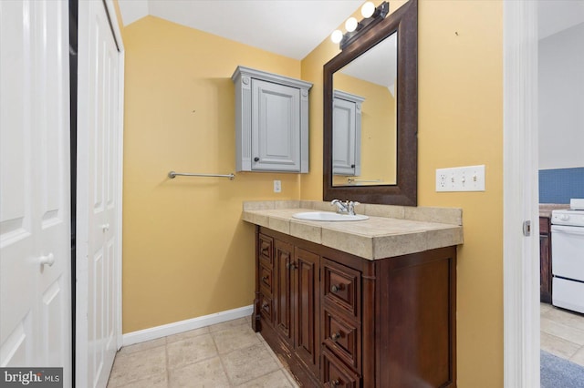 bathroom with vanity, vaulted ceiling, and tile patterned flooring