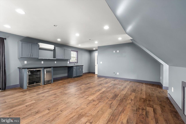 kitchen featuring gray cabinetry, sink, dark hardwood / wood-style flooring, vaulted ceiling, and wine cooler