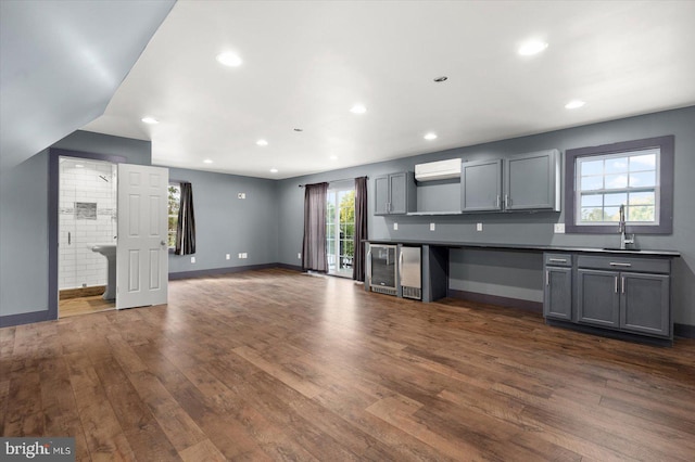 kitchen featuring gray cabinetry, wine cooler, dark wood-type flooring, and a wealth of natural light