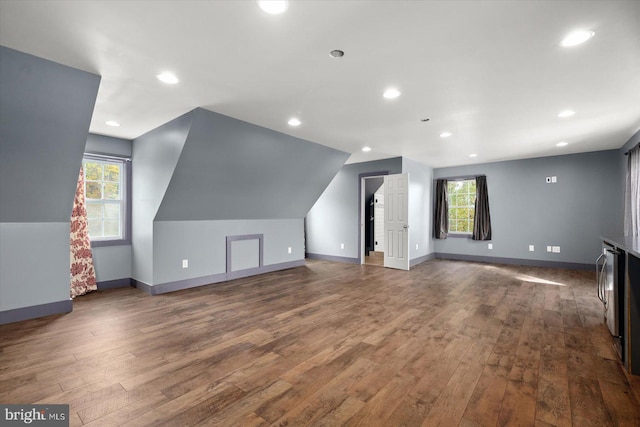 bonus room featuring a healthy amount of sunlight, dark wood-type flooring, and vaulted ceiling