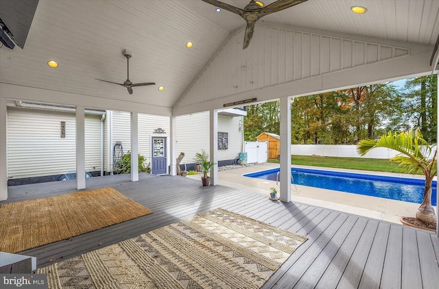 wooden terrace with a fenced in pool and ceiling fan