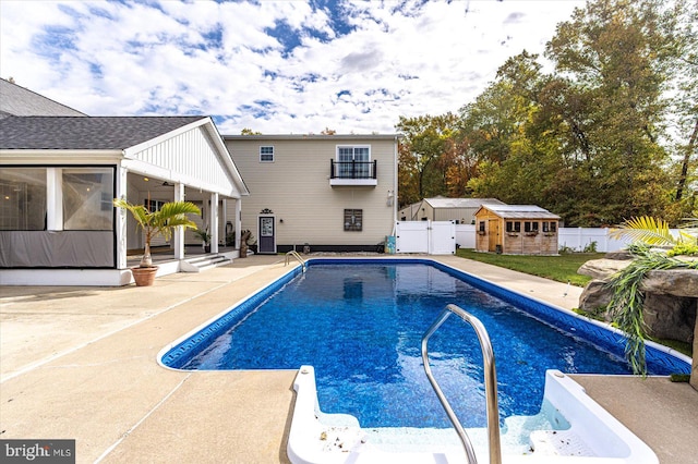 view of swimming pool with a patio and an outbuilding