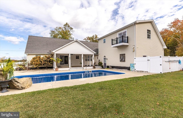 back of house with a patio, a yard, and a balcony