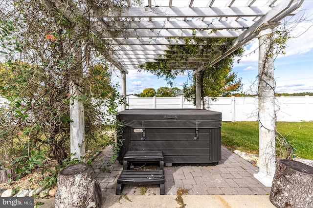 view of patio / terrace with a hot tub and a pergola