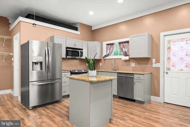 kitchen with light hardwood / wood-style floors, a center island, stainless steel appliances, and sink