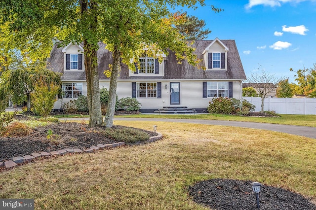 cape cod-style house featuring a front yard