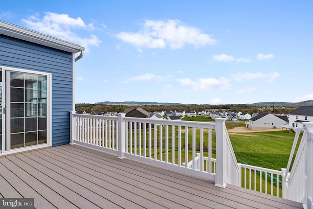wooden deck featuring a yard and a residential view