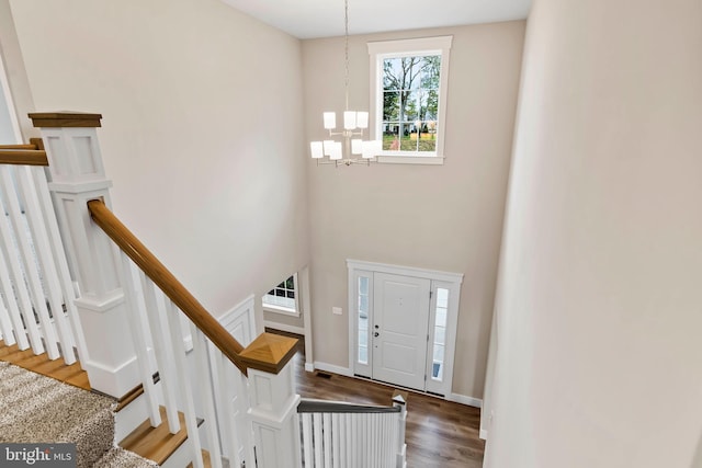 foyer with an inviting chandelier and dark wood-type flooring