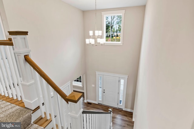 entrance foyer featuring baseboards, wood finished floors, and a chandelier