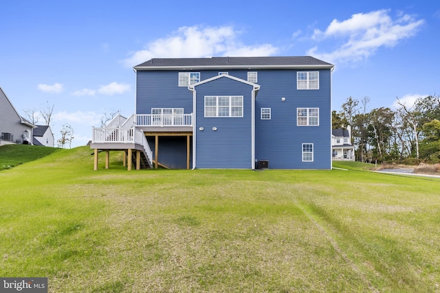 rear view of property with a lawn, a wooden deck, central AC unit, and stairs