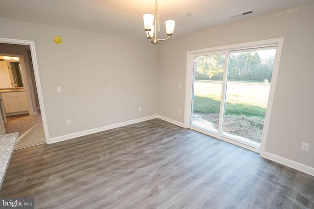 unfurnished room with dark hardwood / wood-style flooring and a chandelier