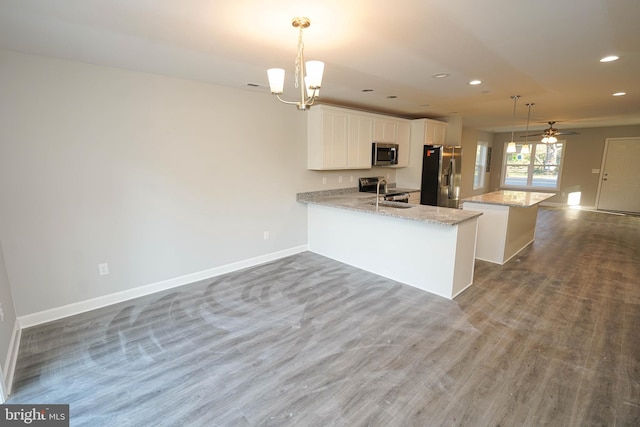 kitchen with white cabinetry, stainless steel appliances, kitchen peninsula, and hanging light fixtures