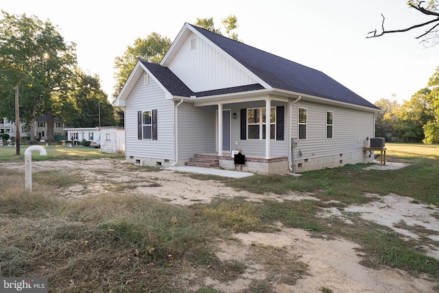 view of front of house featuring a front yard and central AC