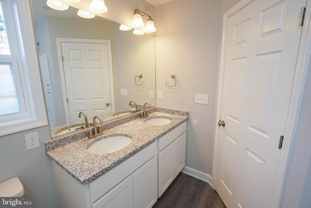 bathroom featuring a wealth of natural light, vanity, hardwood / wood-style floors, and toilet