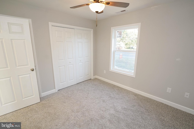 unfurnished bedroom featuring carpet floors, a closet, and ceiling fan