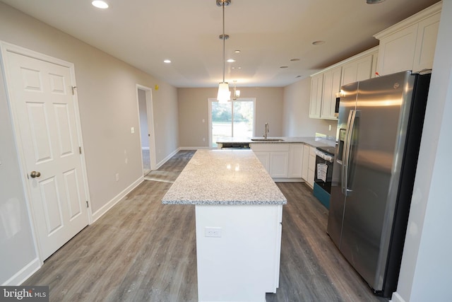 kitchen featuring kitchen peninsula, stainless steel appliances, hardwood / wood-style floors, sink, and white cabinetry