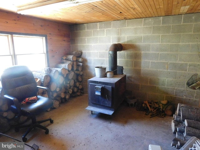 interior space featuring wooden walls, wood ceiling, and a wood stove