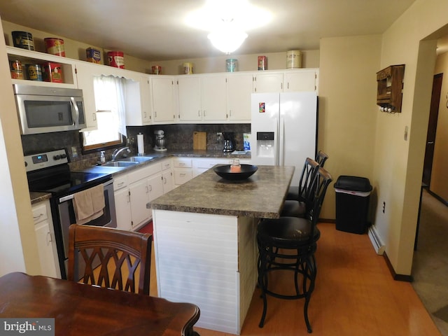 kitchen featuring sink, stainless steel appliances, a center island, and white cabinets