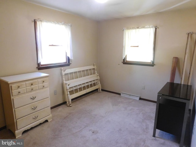 carpeted bedroom featuring a baseboard heating unit