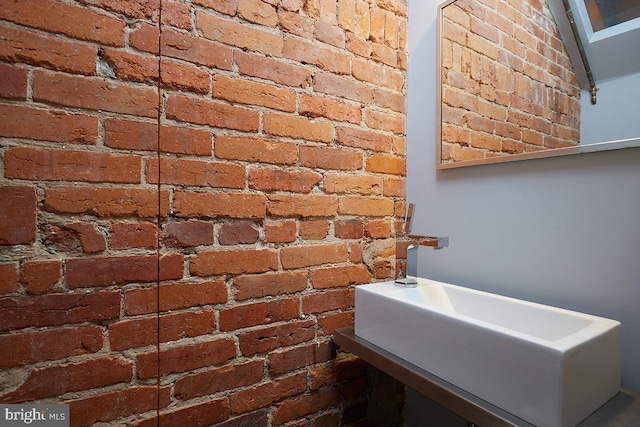 bathroom featuring brick wall