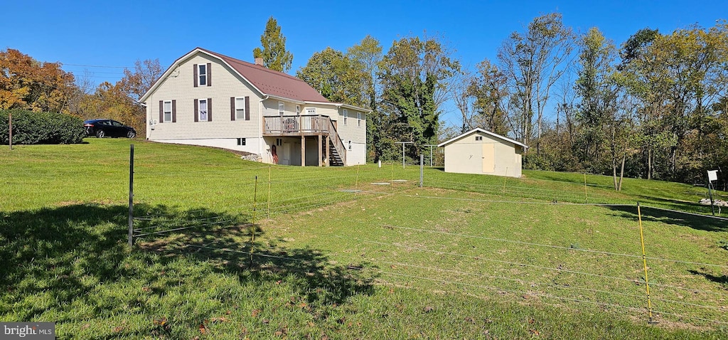 view of yard with a wooden deck and a storage shed