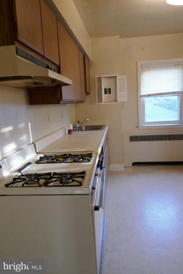 kitchen with sink, white gas range oven, and radiator