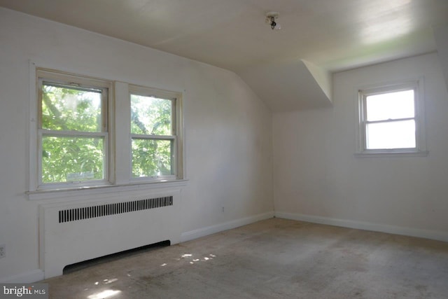 bonus room with lofted ceiling, light colored carpet, and radiator