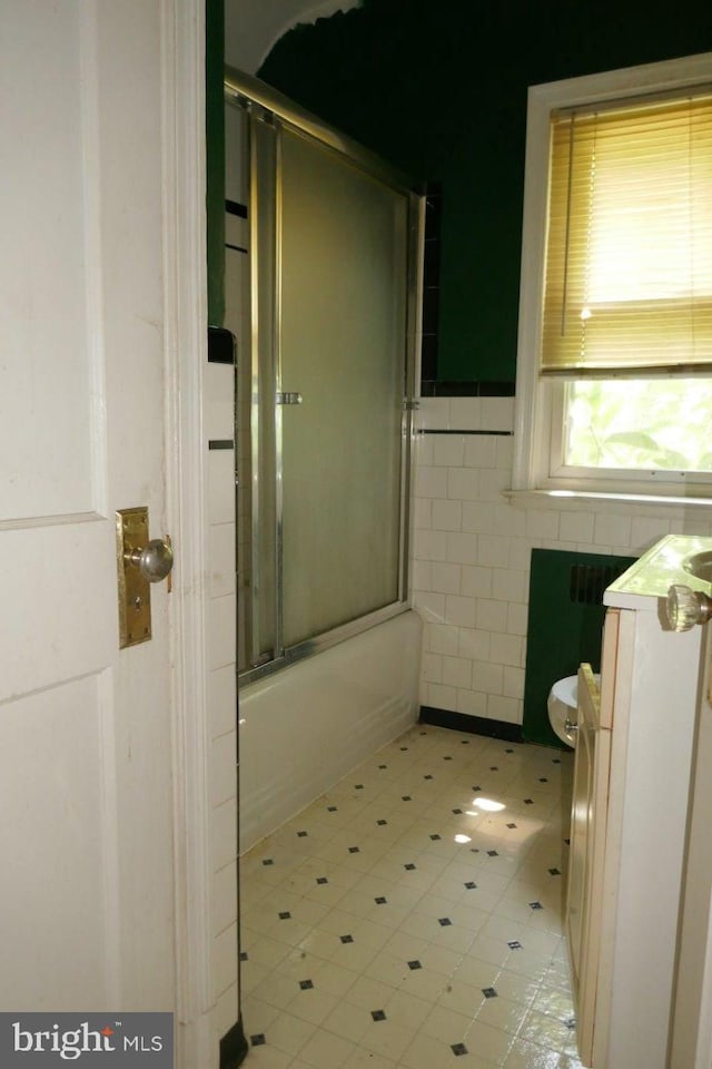 bathroom featuring enclosed tub / shower combo and tile walls